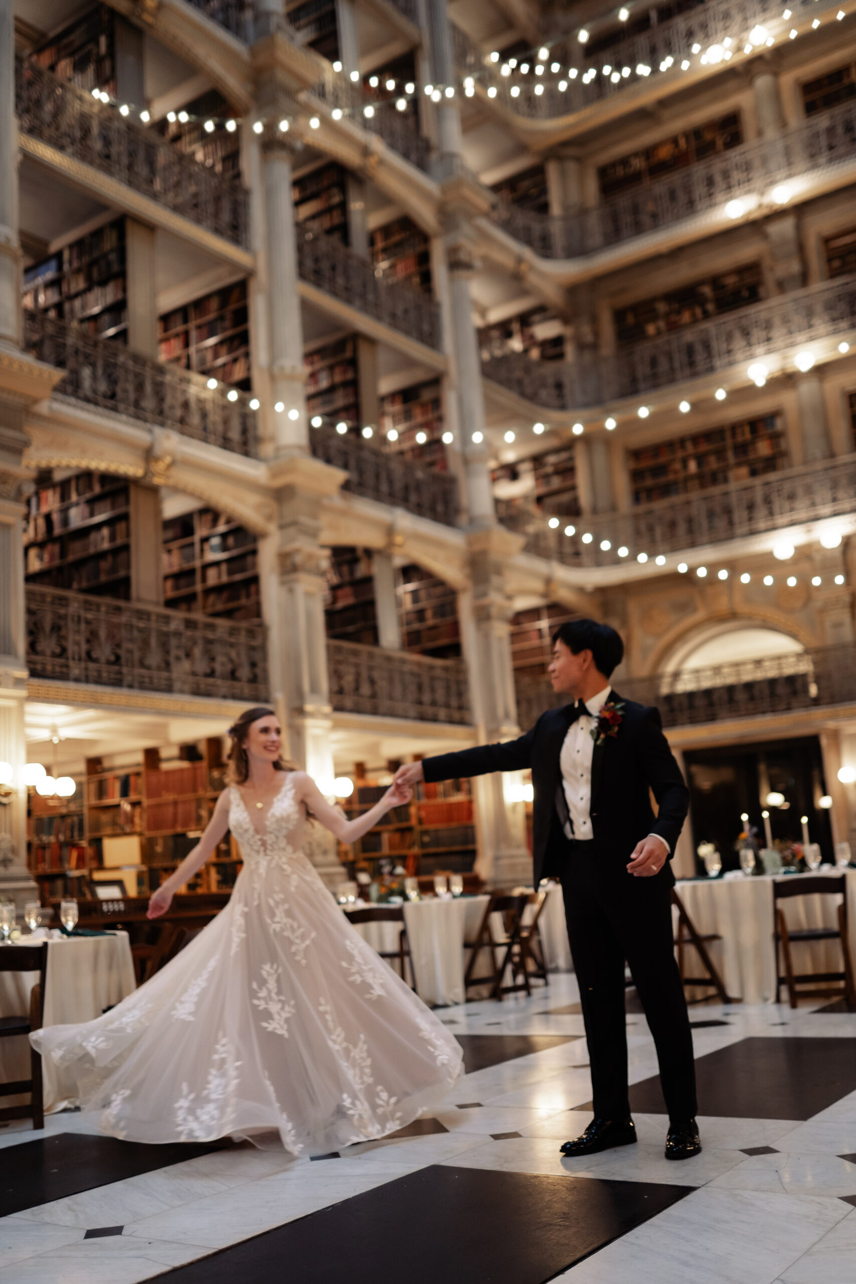 Bride and Groom dancing beneath the bookshelves.